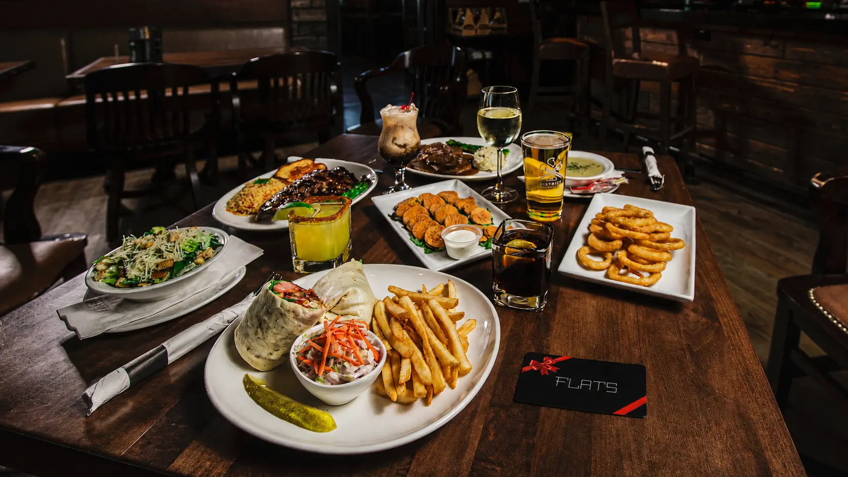 Flats food, drinks and gift card presented around a dining table