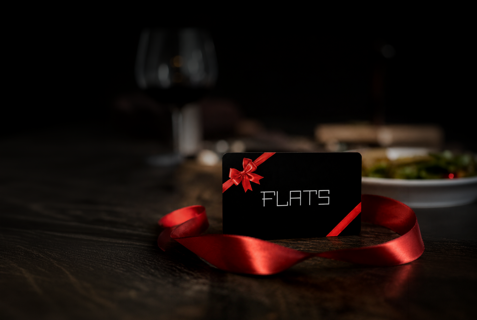 Official Flats gift card presented with a red ribbon